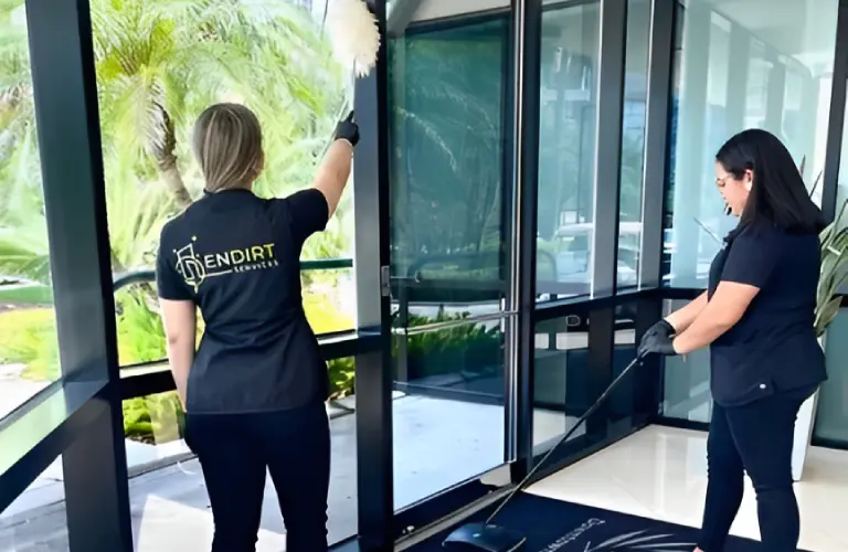 Two people cleaning glass doors indoors.